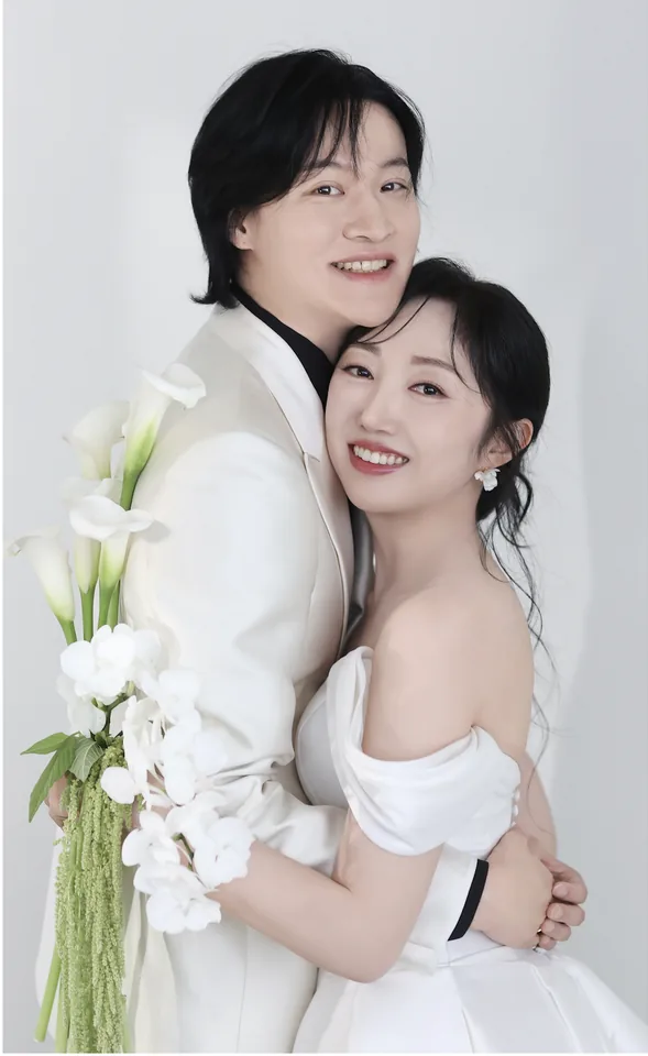 흰 배경 앞에서 서로를 안고 있는 신랑과 신부